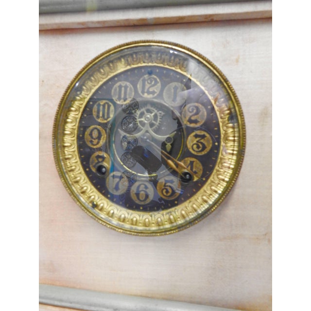 Satin covers the body of this unique Ansonia clock from the late 19th century. The clock is perched on four cast bronze...