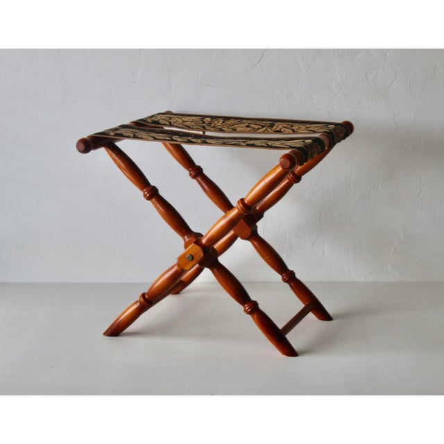 A vintage French beechwood folding luggage rack X-frame stand with turned spindle legs and a patterned tapestry fabric....
