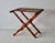 A vintage French beechwood folding luggage rack X-frame stand with turned spindle legs and a patterned tapestry fabric....