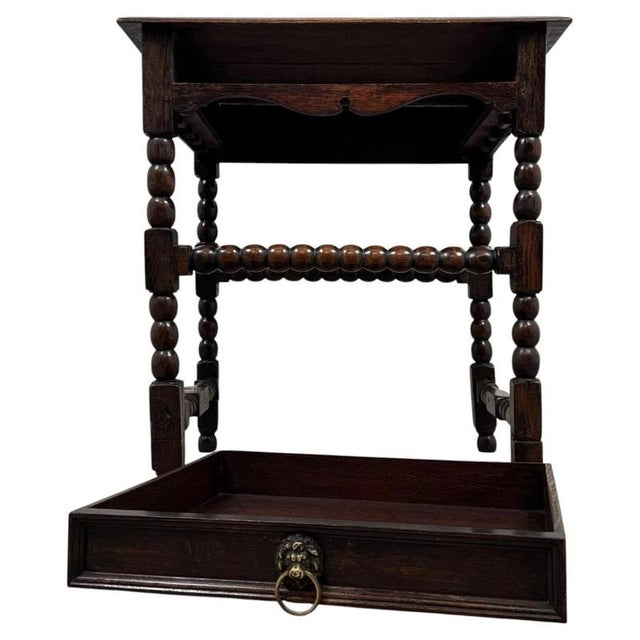 A handsome 19th-century English side table, finely crafted from oak and distinguished by its elegant bobbin-turned legs...