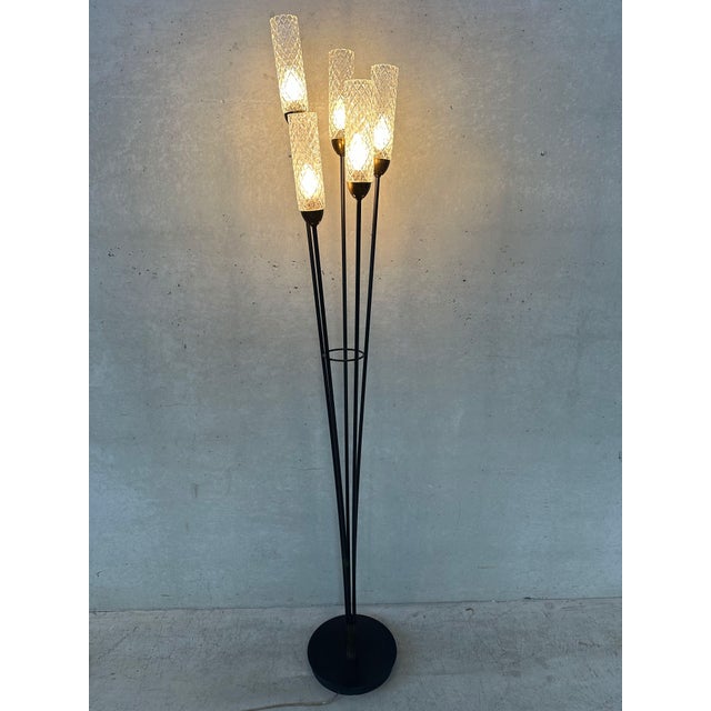 Original 1950s floor lamp with black metal structure and brass details. 5 tubes of textured glass. 5 x E14 sockets. Foot...