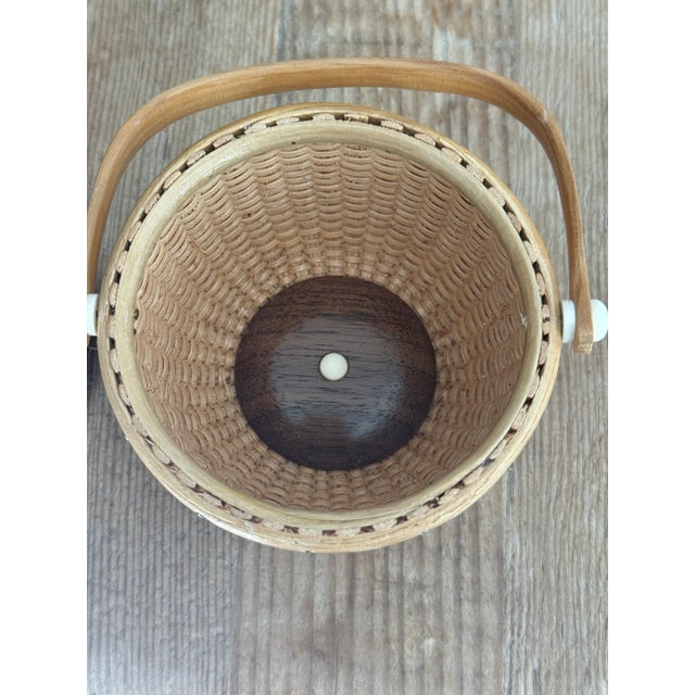 Woven white ash basket Nantucket. Swing arm handle. Natural material knob and sides. Signed on bottom.