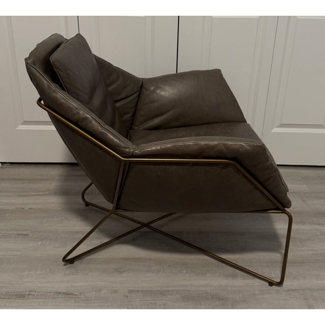 West Elm Origami Leather Armchair featuring soft leather upholstery and a sculptural folded design that gives the piece...