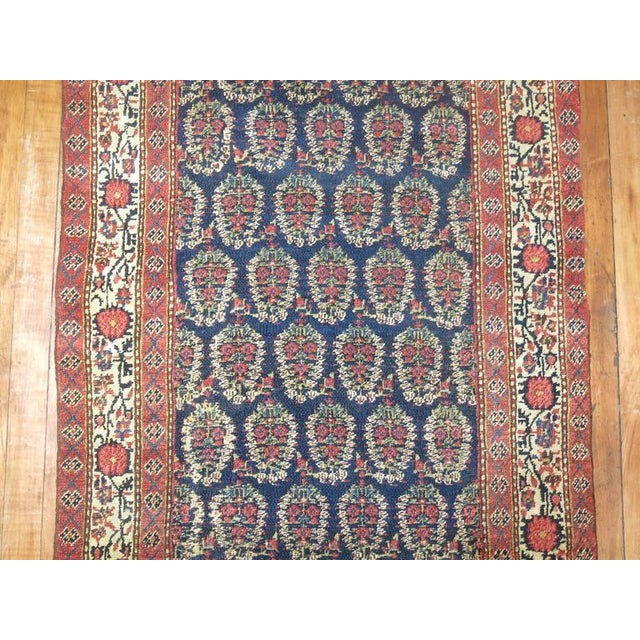 A long and narrow finely woven Persian runner featuring an all-over paisley design. Measures: 2'7'' x 15'8''.