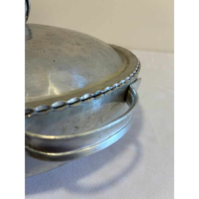 A charming vintage finds serving piece in hand wrought hammered aluminum, featuring an engraved tulip bouquet on the domed...