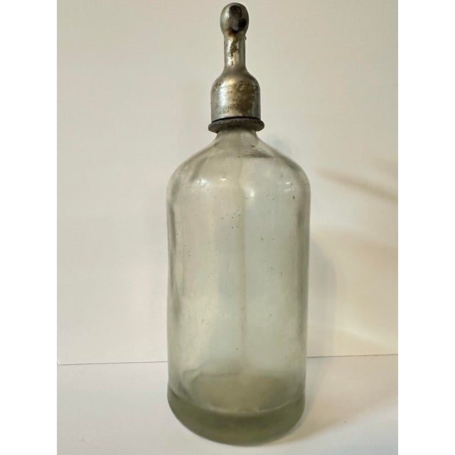 Vintage seltzer/siphon bottle. Thick & heavy glass with silver top. Glass straw inside is intact. Does not open. Measures...