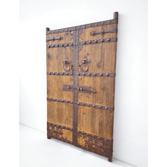 This pair of antique Chinese door panels&nbsp;showcases a blend of traditional craftsmanship through its rustic wood and...