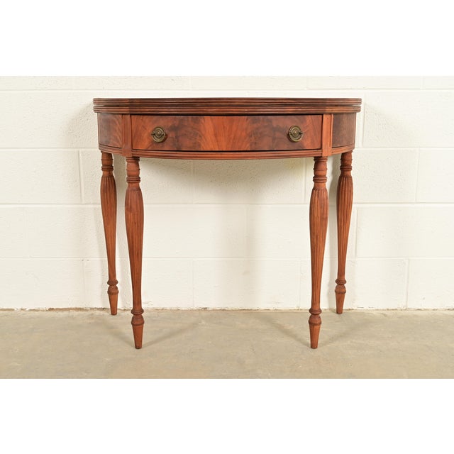 A gorgeous antique Federal, Georgian, or Regency style flip top demilune console game table In the manner of Baker...