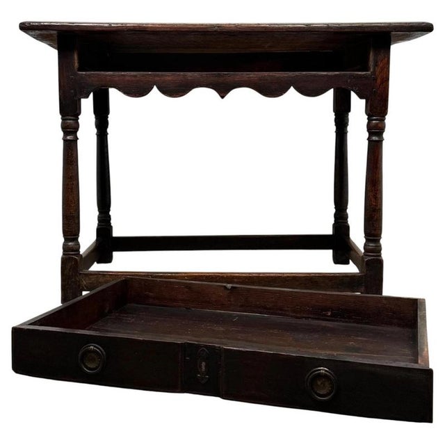 A fine 18th-century English Georgian tilt-top table, beautifully crafted from golden oak and displaying the elegant...