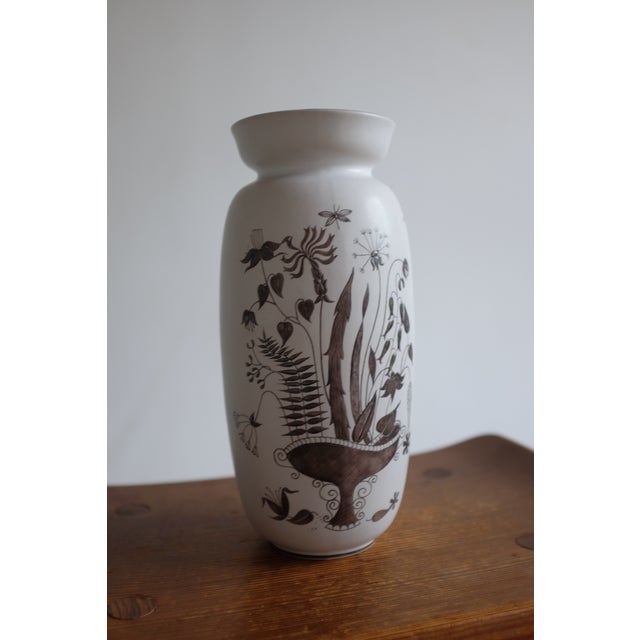 Gorgeous vase in the "Grazia" serie by Stig Lindberg. In a silk-matte white glaze with silver colored flower motif it was...