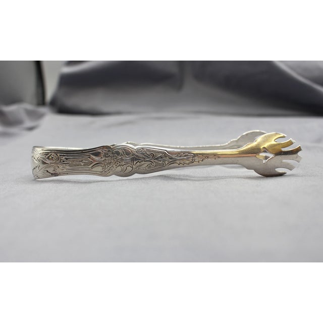 Sterling silver ice or sugar tongs by Manchester Silver Co. Classical motifs & a basket of flowers. Never engraved. 1.40...