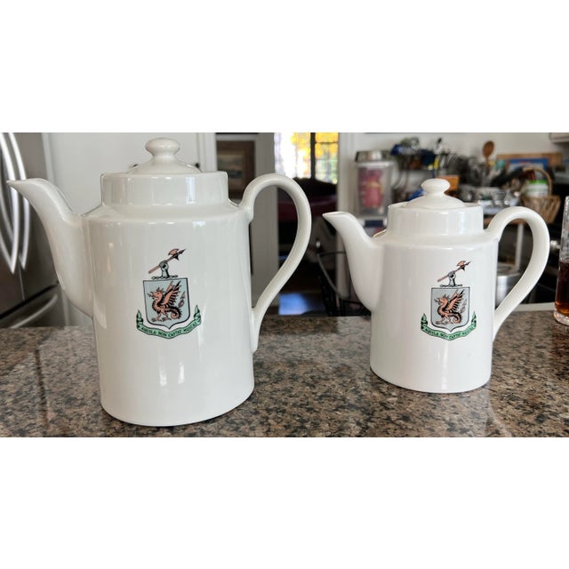Vintage tea pots from the Drake Hotel, chicago, Illinois. The logo on the front translates to, Eagles do not Eat Flies....