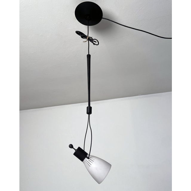 Suspension lamp with splayed steel tube with black painted structure. The diffuser is made of heat-resistant plastic...