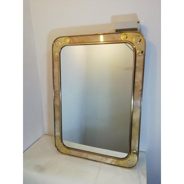 Unique original vintage mirror. It features brass outer edges followed by a thick marble frame and a second brass frame...