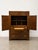 A beautifully made campaign-style cabinet from Drexel Heritage, showcasing rich burl grain and warm honey tones. Solid...