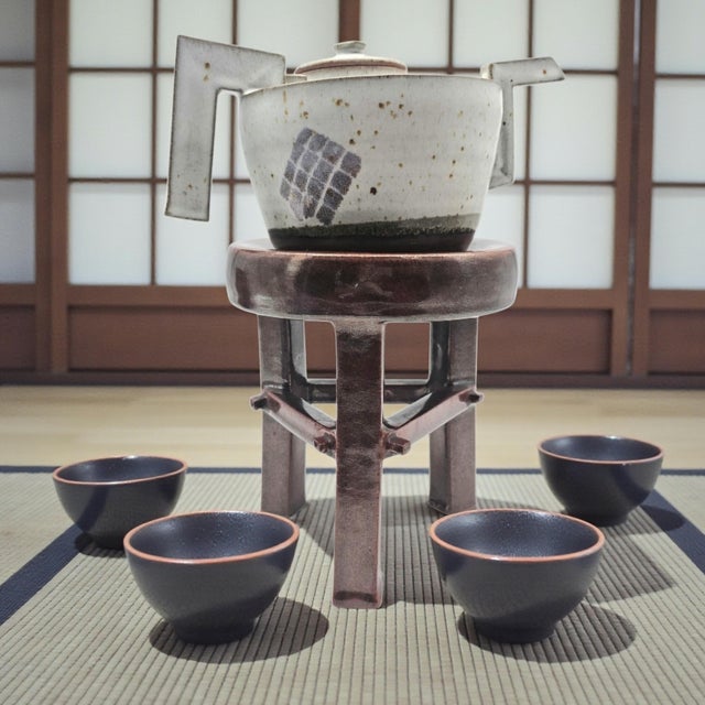 A sculptural late-20th-century studio stoneware teapot presented with its original matching ceramic pedestal stand,...