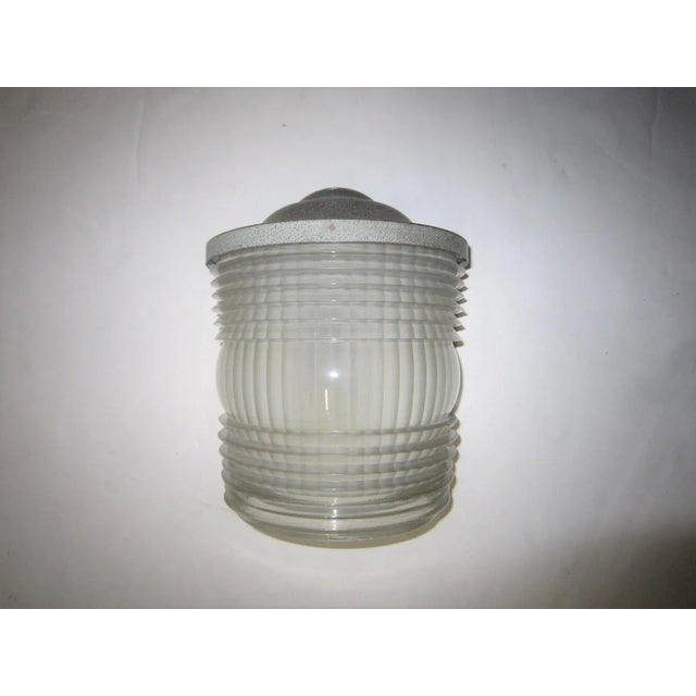 A single original Art Moderne semi-cylindrical sconce spotlighting a heavily molded polished art glass sheath with linear...