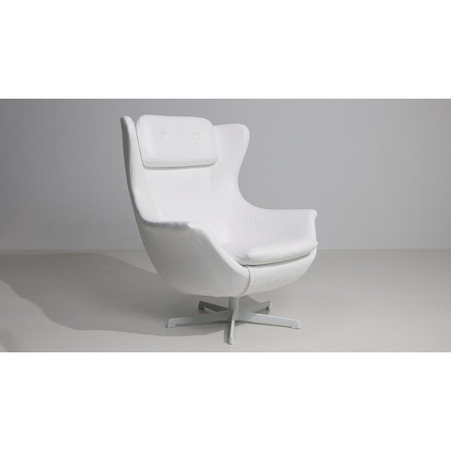 A 20th century swivel armchair attributed to Kelo, featuring a metal frame combined with upholstered elements. The design...
