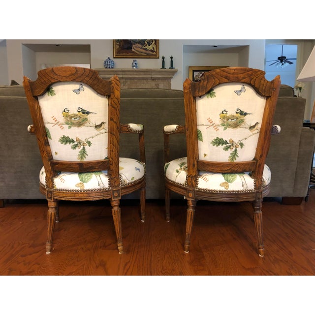 Two French XVIII century upholstered arm chairs (certified by Azur Enchères, Cannes, France.), oak back-rest in hat shape...
