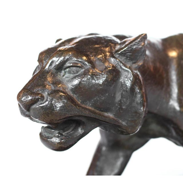 An Art Deco, patinated bronze study of a prowling tiger, set over an integral marble base. Signed to marble. Artist: Henri...