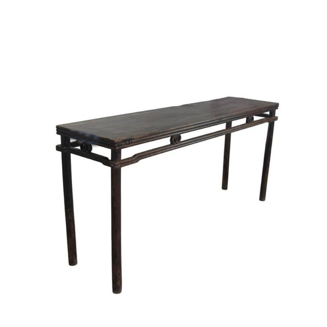 This elongated table features a slender profile with a flush-panel top. The design is distinguished by its "double-...