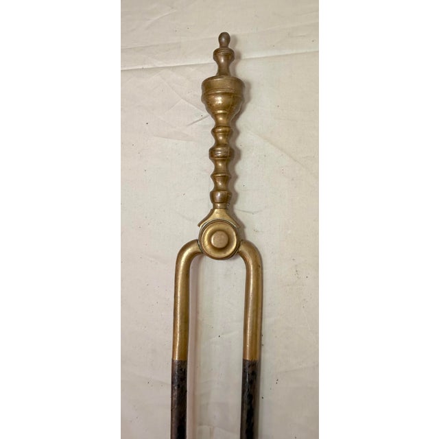 Up for sale is a nice pair of rare antique 18th century wrought iron and brass English fireplace tongs. The arms are...