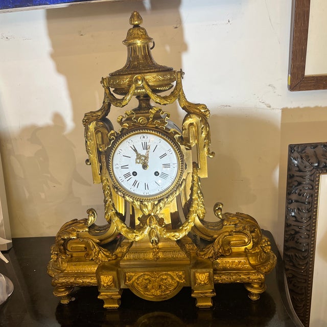 The case surmounted by an urn and trailing swags overs tiff scroll supports, foliage, husks, and vitruvian scrolls. Late...