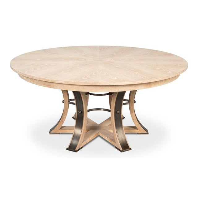 Pale bleached oak meets a sculptural pedestal beneath a circular top that expands for larger gatherings. The softly...