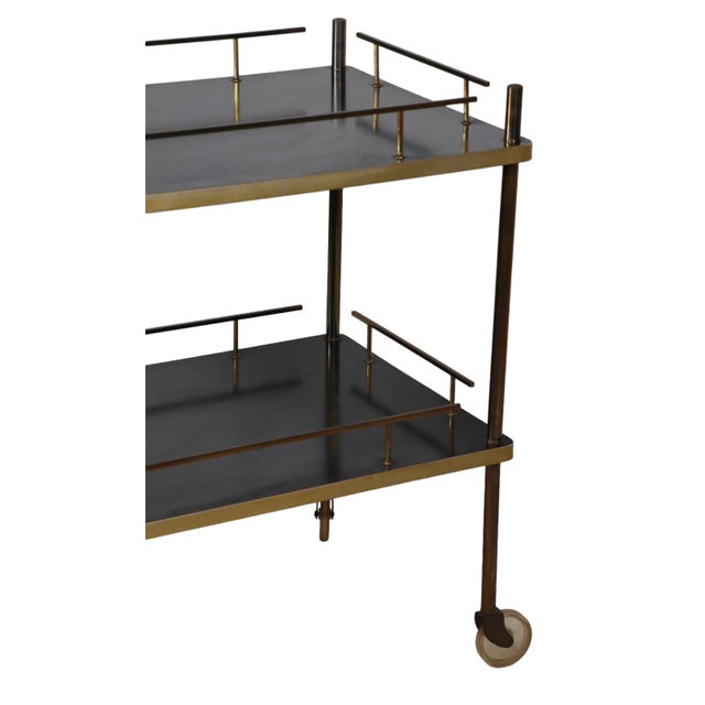 Chic, sophisticated and stylish dry bar, serving cart having a brass frame, and black laminate shelves surface. This...