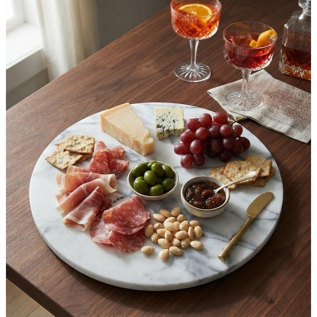 A beautiful 14-inch round marble board showcasing elegant white and grey veining and a smooth polished surface. Its...