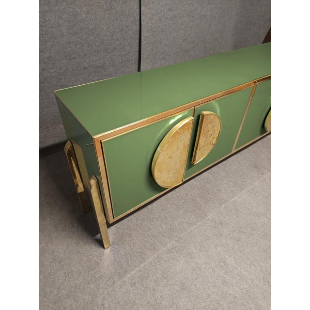 Green glass four-door sideboard with brass fittings and handles This exquisite sideboard represents the pinnacle of...