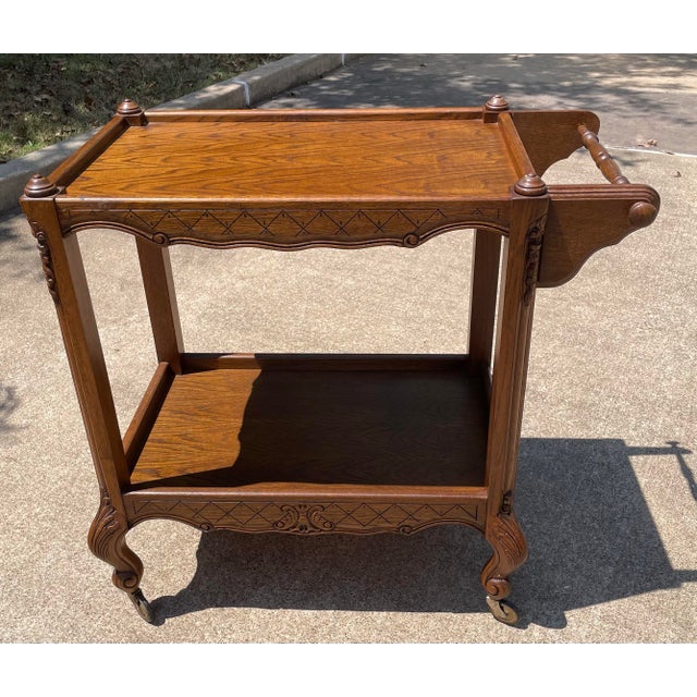 French country two level bar cart with handle and wheels. Nice carved details and tall size.