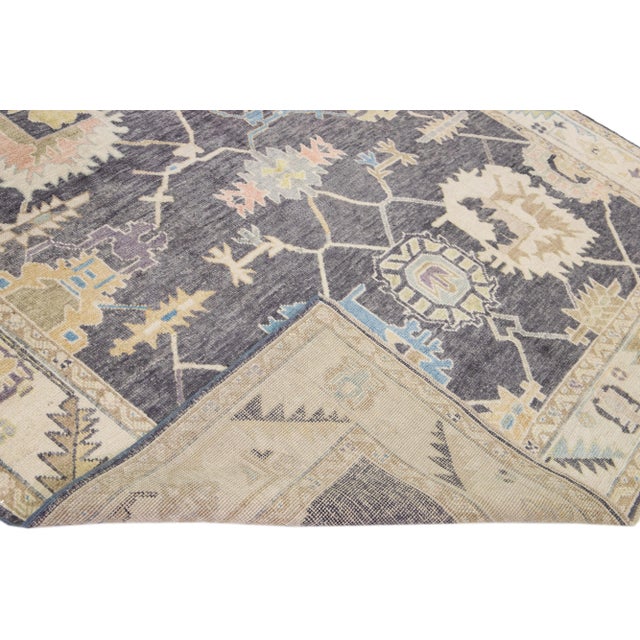 Beautiful modern Oushak hand-knotted wool rug with a gray field. This Turkish rug has a beige frame and multicolor accents...