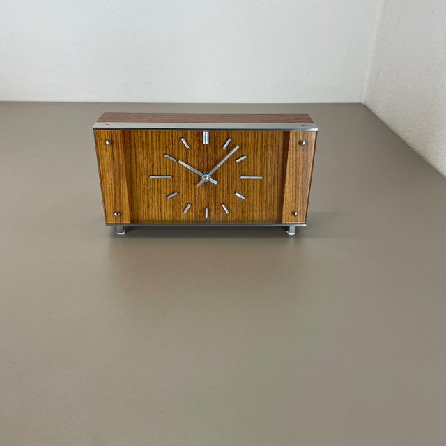 Article: clock, usable as table and wall clock Origin: Germany Producer: Junghans, Germany Age: 1970s This original wooden...