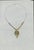 Original jewelry design drawing of an ornate pendant necklace with a ribbed gold-tone central form and small green jewel-...
