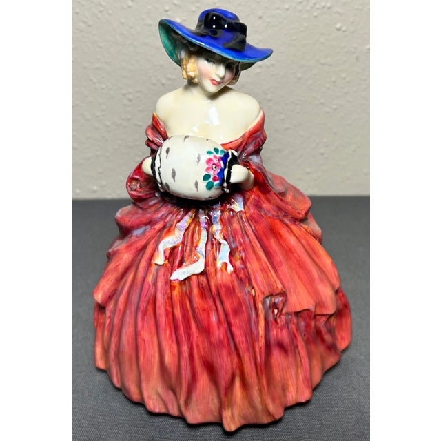Up for sale is a 1943 English Royal Doulton Porcelain Genevieve Figurine (HN 1962) (Retired)! It measures 7 1/8” tall. The...