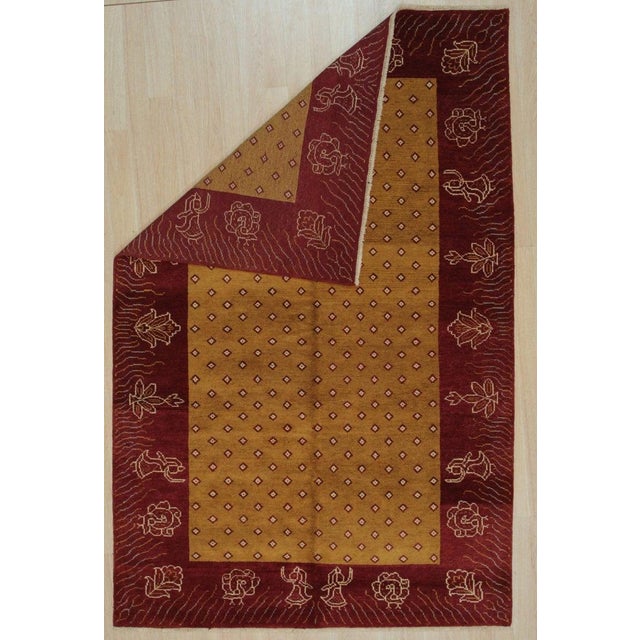 This hand knotted pile rug is crafted from wool and features a primary color scheme of yellow, gold, and orange. Produced...