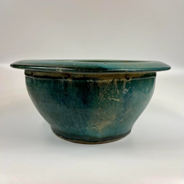 This is a beautiful and elegant ceramic planter bowl with a small detail around the rim. The planter has a drainage hole...