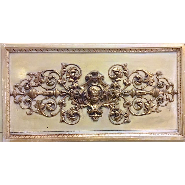 Antique brass and wood cherub and acanthus leaf wall plaque. Exhuberant acanthus foliate scrolls surround a Cherub face....