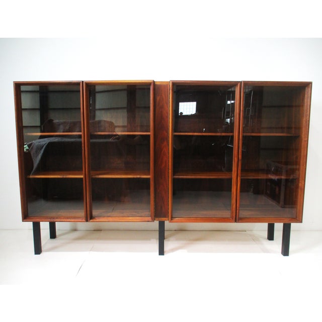 An exceptionally crafted black walnut bookcase with four wood framed glass doors having piano hinges showing the great...