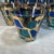 This stunning collection of vintage mid-century modern glassware features a vibrant blue and green stained-glass mosaic...