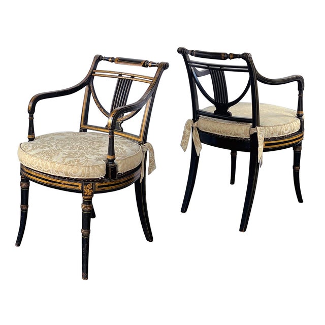 a pair of early 19th-century Regency armchairs, ebonized with gilt stencil decoration; each features a double-baluster...