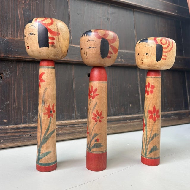 A beautiful set of three handcrafted kokeshi dolls in the classic Tsuchiyu style, originating from Miyagi Prefecture — one...