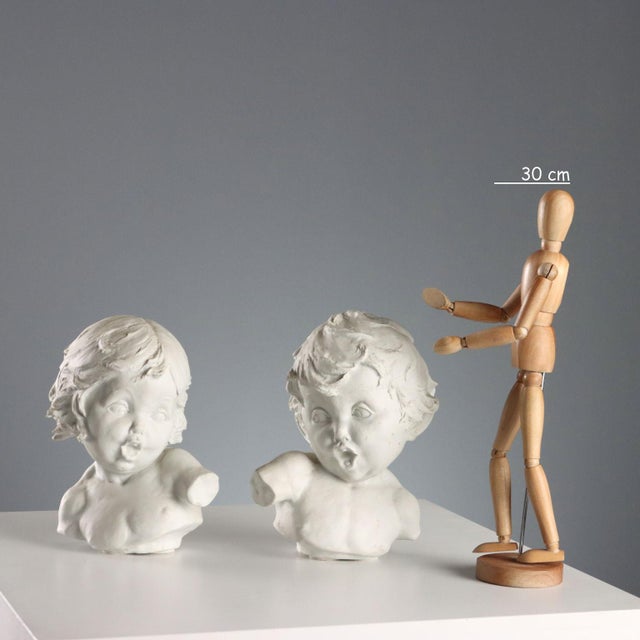 Pair of mirrored biscuit sculptures depicting busts of children. This piece is attributed to the mentioned designer/maker....