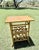 A charming vintage faux bamboo side table featuring a woven rattan top and an integrated magazine rack with decorative...