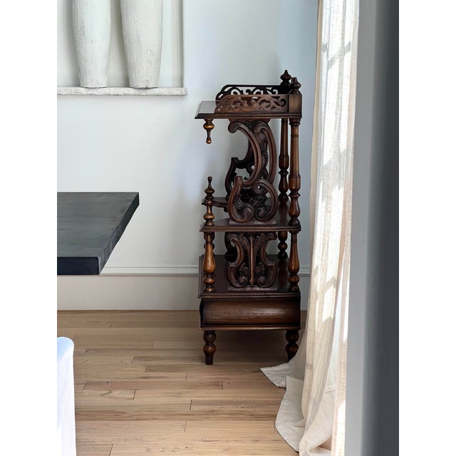 An elegant late Victorian English étagère, circa 1880, crafted in richly toned wood and designed for refined display. This...