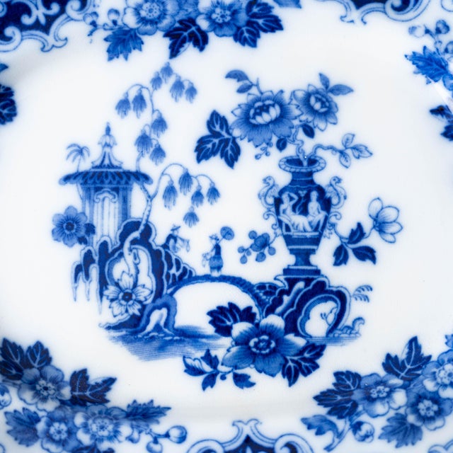 Oval earthenware platter transfer-printed in blue with chinoiserie garden scene of pagoda, flowering urn, and scrolling...