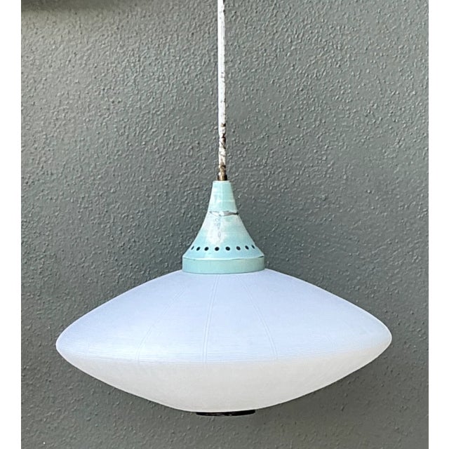 Showcasing retro Space Age design influences, this 1960s pendant light features a broad, saucer-shaped frosted glass...