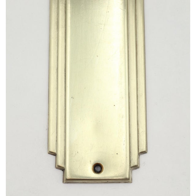Art Deco style door push plate made of brass with a polished finish. The original mounting screws are not available. Good...