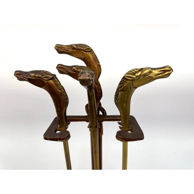 This vintage brass fireplace tool set showcases equestrian elegance with sculptural horse head handles on each piece,...